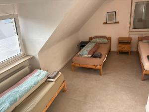 a room with three beds and a window at Hauckwald Apartment 1 in Alzenau +1 photo