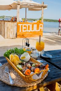 a picnic table with a basket of food and a drink at Koko Beach - Honeymoon Suite in Vila Praia Do Bilene +8 photos