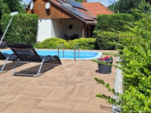 a patio with a chair next to a swimming pool at Boglárka Vendégház in Vasvár