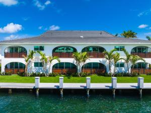 a house on the water with a dock at Casa Coral - Boca Poolside Escape in Boca Raton