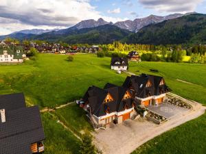 an aerial view of a house with mountains in the background at Rogata Chata Tatra View & Jacuzzi in Kościelisko