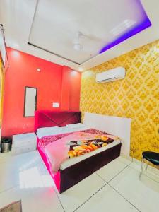 a bedroom with a bed with a red wall at Hotel RKS Residency in Bathinda