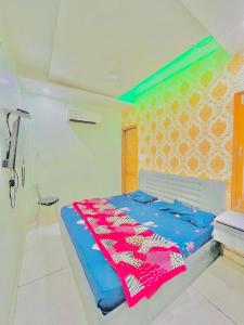 a bedroom with a bed with a blue blanket on it at Hotel RKS Residency in Bathinda