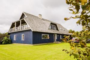 a blue house with a gambrel roof at Tiiupesa Guest House in Hellamaa