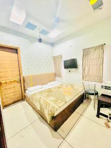 a bedroom with a bed and a desk and a television at Hotel RKS Residency in Bathinda