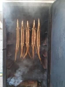 a row of fish are cooking on a grill at Tiiupesa Guest House in Hellamaa