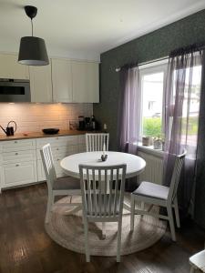a kitchen with a white table and chairs and a window at Känslans in Årjäng