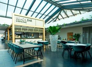 a restaurant with tables and chairs and a bar at NH Noordwijk Conference Centre Leeuwenhorst in Noordwijkerhout +35 photos