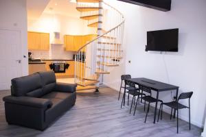 a living room with a couch and a table with chairs at Luton Grove in Liverpool