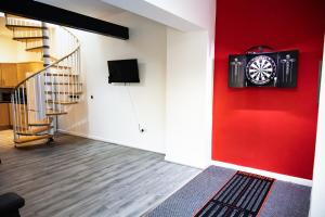 a room with a red wall with a clock on the wall at Luton Grove in Liverpool