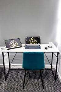 a table with two laptops and a blue chair at Luton Grove in Liverpool +35 photos