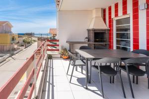 a balcony with a table and chairs and a fireplace at Salt & Sand Costa Nova Beach in Costa Nova