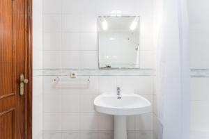 a white bathroom with a sink and a mirror at Salt & Sand Costa Nova Beach in Costa Nova +31 photos