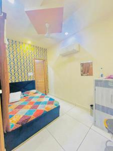a bedroom with a bed with a colorful quilt at Hotel RKS Residency in Bathinda