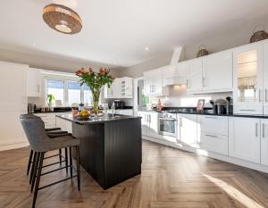 a kitchen with white cabinets and a black island at The Iveragh in Kenmare +62 photos