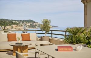 a balcony with tables and chairs and a view of the ocean at Hotel Palais de la Mediterranee, in the Unbound Collection by Hyatt in Nice