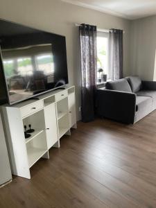 a living room with a couch and a flat screen tv at Känslans in Årjäng