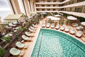 an overhead view of a hotel pool with chairs and umbrellas at Hotel Palais de la Mediterranee, in the Unbound Collection by Hyatt in Nice