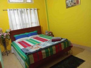 a bedroom with a bed with a colorful blanket at niribili homestay in Dibrugarh