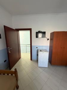 a room with a door and a refrigerator and a television at Hotel Parking Pika in Shëngjin