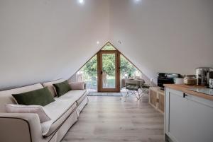 a living room with a couch and a kitchen at The TreeHouse Hideaway in Shrewsbury