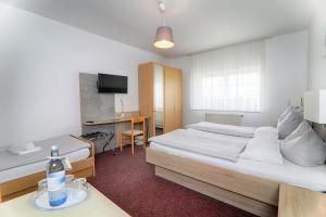 a bedroom with a bed and a desk with a bottle of water at Hotel Reuterhof in Reuterstadt Stavenhagen