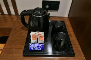 a tray with a coffee pot and drinks on a table at Hotel Namaskar India - Just A Minute Away From New Delhi Railway Station & Connaught Place in New Delhi