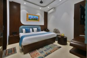 a bedroom with a large bed with a blue chair at Hotel Namaskar India - Just A Minute Away From New Delhi Railway Station & Connaught Place in New Delhi +43 photos