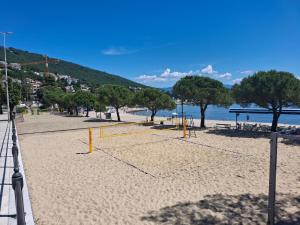 a volley ball court on a beach with trees at Tivoli Apartment in Ičići