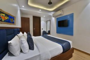 a bedroom with a large white bed with a blue wall at Hotel Namaskar India - Just A Minute Away From New Delhi Railway Station & Connaught Place in New Delhi