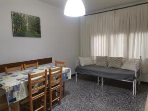 a dining room with a table and a couch at Carrer Esparreguera in Olot