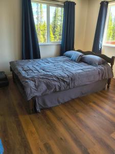 a bed in a bedroom with a wooden floor at Soldotna-Kenai Peninsula House in Soldotna