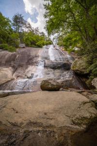a waterfall on the side of a mountain with trees at Little Elves Overlook in Sparta