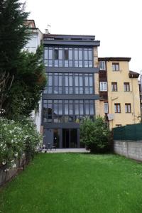 a large black building with a lawn in front of it at MoV Flexliving in Oviedo