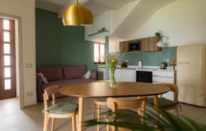 a kitchen with a table and chairs in a kitchen at Sky & Vineyards - Melograno - in La Morra