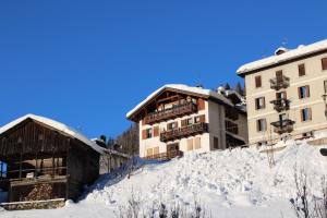 eine Gruppe von Gebäuden im Schnee neben Gebäuden in der Unterkunft CasaColdai in Alleghe