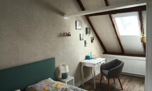 a bedroom with a bed and a desk and a window at Bed and Breakfast en Sarthe in Avoise +7 photos