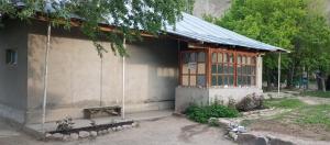 a small building with a bench in front of it at Памирский дом in Khorog