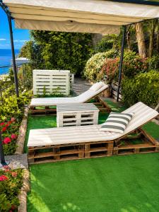 eine Terrasse mit zwei Stühlen und einem Pavillon in der Unterkunft Encanto do Sol in Ponta do Sol