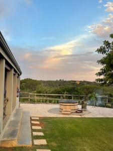 a fire pit in a yard with a view of a field at River House at Rivierplaas in Stilbaai