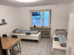 a room with two beds and a table and a window at Hauckwald Apartment 5 in Alzenau