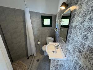 a bathroom with a sink and a toilet and a mirror at Razos Windmill in Vathi +44 photos