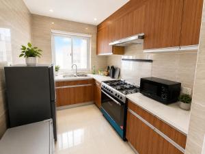 a kitchen with a black stove and a sink at Residential Capital Plus in Accra