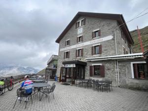 a person sitting at a table in front of a building at Albergo Genziana in Bormio