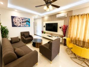 a living room with a couch and a tv at Residential Capital Plus in Accra