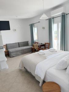 a bedroom with a large bed and a couch at Argo Rooms Antiparos in Antiparos