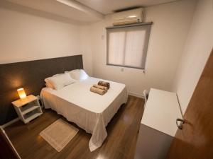 a small bedroom with a bed and a window at Flamboyant Stay Rooms in Goiânia