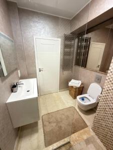 a bathroom with a white toilet and a sink at Sophia Luxury Residence in Mamaia +6 photos