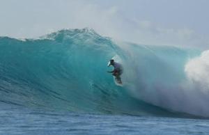 a man riding a wave on a surfboard in the ocean at Royal Palms Resort in Arugam Bay