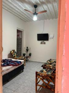 a living room with two beds and a flat screen tv at Casa a 3 minutos da basilica in Aparecida
